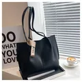 Detail of a large black matte tote bag with vertical stitching and chic ribbon decoration - Black