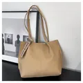 Detail of minimalist apricot leather tote bag featuring sleek stitching and fashion ribbon - Khaki