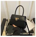 Dettaglio della borsa squadrata nera in pelle con chiusura dorata e catenella - Nero