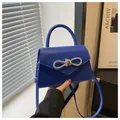 Dettaglio della borsa blu reale con fibbia a fiocco in strass e manico superiore - Blu