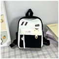 Détail d'un sac à dos en toile noir et blanc avec breloque raton laveur et sangles de mode - Noir