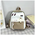 Détail du sac à dos scolaire minimaliste avec panneaux beige et kaki et écusson - Kaki