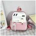 Dettaglio ravvicinato dello zaino rosa e bianco con toppe di animali e logo FASHION - Rosa
