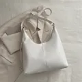 Minimalist white PU leather half-moon tote bag with gold hardware and adjustable strap - White