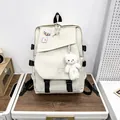 Detail van een grote beige canvas rugzak met zwarte gespen en een pluche beer hanger - Wit