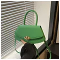 Détail d'un sac à main carré vert vif avec boucle dorée en forme d'éventail et poignée - Vert