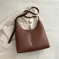 Dunkelbraune Hobo-Schultertasche aus Leder mit vertikaler Naht und verstellbarem Riemen - Braun
