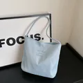 Light blue nylon shoulder bag featuring elegant embroidery and modern minimalist design - Standard / Blue