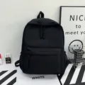 Minimalist black large capacity nylon backpack with front pocket and woven zipper pulls - Black