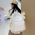 Minimalist beige high-capacity backpack for students with a plush bear charm - White