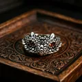 Macro detail of retro animal totem ring with red gemstone eyes and scales on metal - J274 Owl