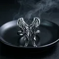 Macro shot of vintage silver metal wings ring with antique finish on black plate - J290 Wings