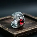 Detailed macro view of vintage feather ring with red gemstone and silver metal texture - J321 Red Eyes