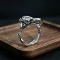 Macro detail of a silver dragon wrap ring featuring intricate scales and wings on wood - J332 Little Dinosaur