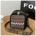 Detail der bunten Ethno-Mini-Tasche mit goldenen Reißverschlüssen und geometrischem Gurt - Schwarz