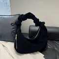 Modern black corduroy hobo bag with ruched handle design and golden metal zipper detail - Black