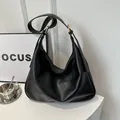 Große schwarze Schultertasche aus Kunstleder mit goldenen Metalldetails für Damen, Hobo-Stil - Schwarz