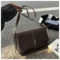 Dettaglio della borsa a tracolla vintage marrone scuro con fibbia in metallo e trama in pelle - Caffè