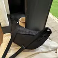 Minimalistische schwarze Nylon-Umhängetasche in Halbmondform mit verstellbarem Gurt - Schwarz