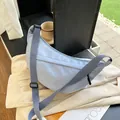 Minimalistische hellblaue Halbmond-Umhängetasche aus Nylon mit verstellbarem Gurt - Blau