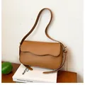 Minimalist caramel brown shoulder bag with a unique wave flap and golden hardware - Brown