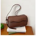 Deep brown crossbody bag with scalloped flap edge and slim strap on minimalist books - Brown
