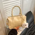 Chic beige Boston handbag with embossed lettering, gold hardware and plush pompom charm - With Plush Charm / Off White