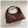 Detalle del bolso hobo de ante sintético marrón oscuro con doble costura sobre pana blanca - Marrón