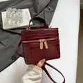 Bolso caja color burdeos con patrón de cocodrilo, asa superior y correa de hombro - Rojo