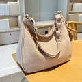 Bolso hobo beige mate con cadena de metal dorado sobre escritorio de madera - Caqui