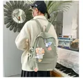 Dettaglio zaino in tela verde chiaro con distintivi a cartone animato e ciondolo di peluche - Taglia Unica (Senza Ciondolo) / Verde chiaro