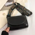 Chic black crossbody bag with white contrast stitching and wide ethnic pattern strap - Black