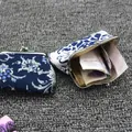 Detail van vintage canvas portemonnees met blauwe bloemmotieven en metalen sluiting - Blauw