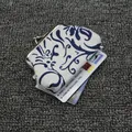 Detail van de vintage canvas portemonnee met blauwe bloemenprint en metalen kliksluiting - Wit