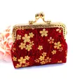 Close-up of a handmade red fabric coin purse with gold cherry blossoms and kiss lock clasp - Red
