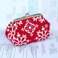 Detailopname van een rode etnische stoffen portemonnee met witte patronen en gouden sluiting - Rood