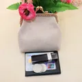 Detailed close-up of beige linen coin purse with vintage gold clasp and daily essentials - White