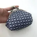 Detailopname van een hand die een zwart-witte houndstooth tweed knipbeurs vasthoudt - Zonder Parels Stijl / Zwart