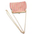 Detail van rood-groene geblokte stoffen tas met goudkleurige sluiting en ketting - Oranjerood