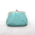 Detail van mintgroene munttas met clipsluiting en sprankelende iriserende glitters - Meer blauw