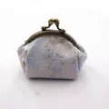 Detail van vintage blauwe brokaat portemonnee met gelukskat patroon en bronzen sluiting - Blauw