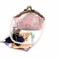 Detail van roze brokaat gelukskat portemonnee met parelhandvat en metalen sluiting - Aparte Parelketting Accessoire (Zonder Tas)