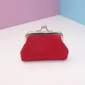 Close-up of red canvas coin purse featuring vintage metal kiss-lock and textured fabric - Red