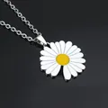 Detail van madeliefje hanger met witte blaadjes en geel hart op zwart spiegelend vlak - Zoete Madeliefje Stijl / Wit met gele kern