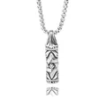 Detailed macro view of relief textures on vintage stainless steel capsule necklace - Engraved Cylinder Style