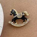 Macro shot of rocking horse brooch with black enamel, gold metal, and sparkling rhinestones - Black