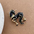 Makroaufnahme einer Einhorn-Brosche mit schwarzer Emaille und Kristallen auf Goldlegierung - Einhorn Pferd Stil / Schwarz