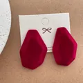 Macro shot of irregular red flocked earrings on white card with fine velvet texture - Irregular Large Style