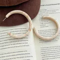 Vintage C-Form Creolen aus Acetat mit Crememarmor-Textur auf braunem Wollhut und Buch - C-förmiger Marmormuster-Stil (F-19) / Gebrochenes Weiß