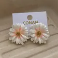 Elegant white daisy stud earrings with golden centers and subtle glitter on a beige tray - White Pink